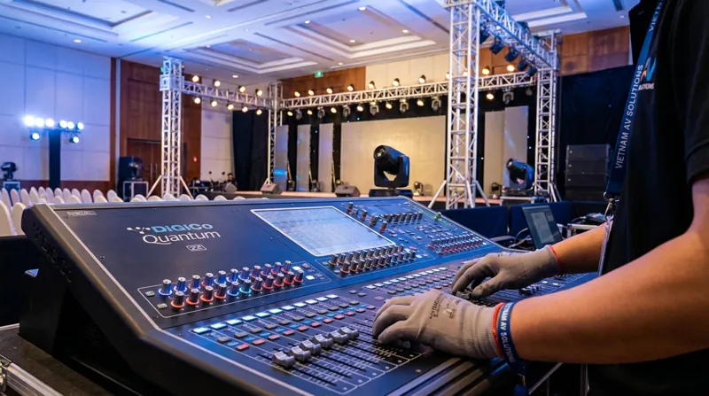 Kỹ thuật viên đang setup hệ thống âm thanh ánh sáng hội nghị chuyên nghiệp, gọn gàng.